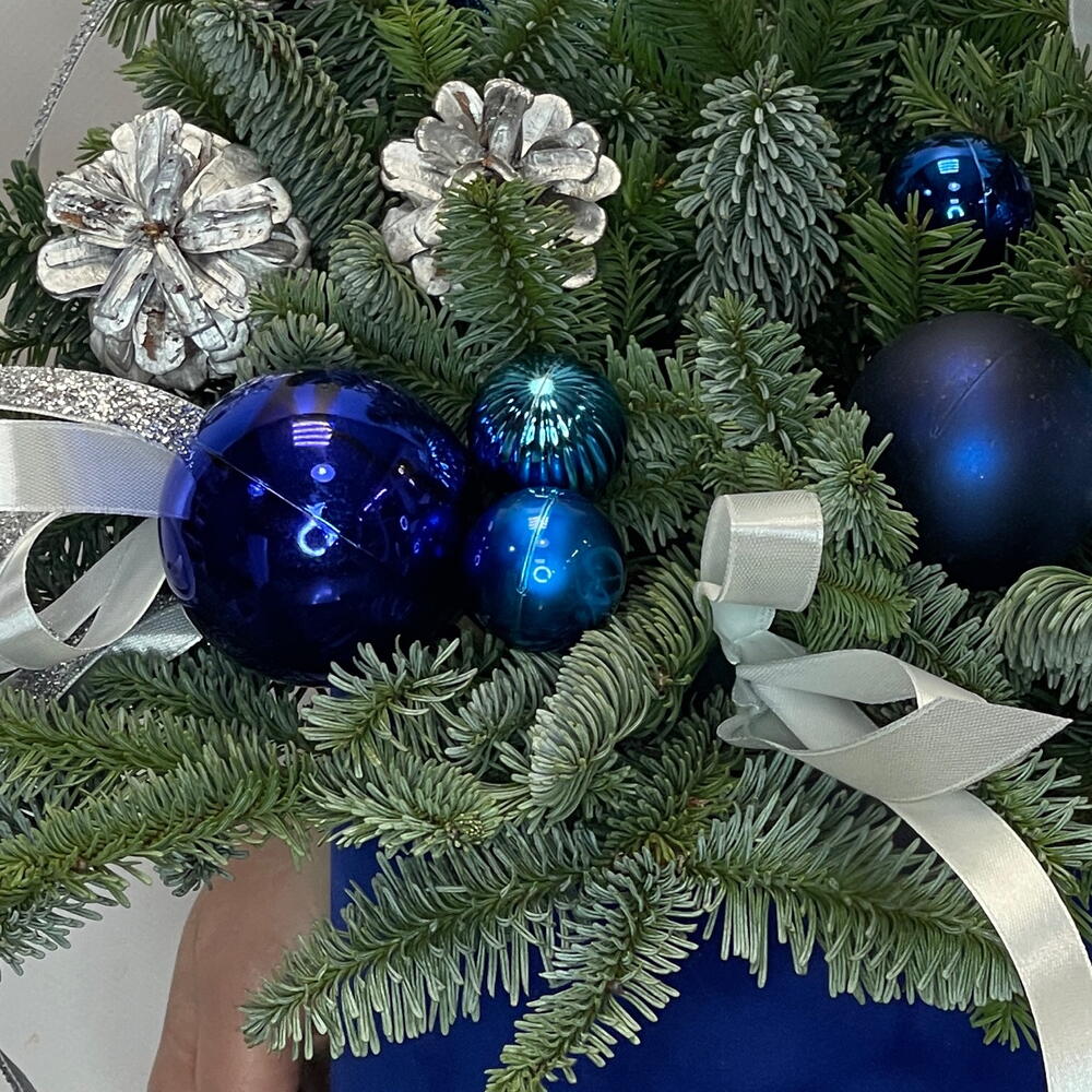 Новогодняя композиция из живой ели с шишками и игрушками